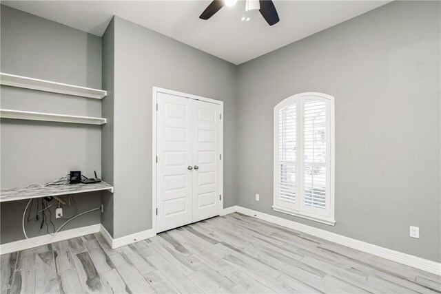 bedroom with a closet, baseboards, ceiling fan, and light wood finished floors