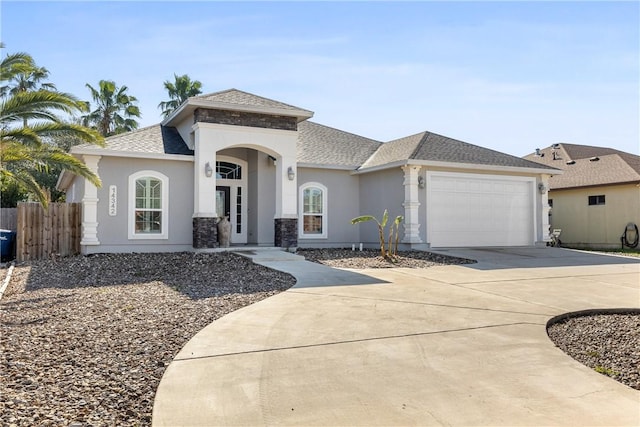 view of front facade featuring roof with shingles, stucco siding, fence, a garage, and driveway