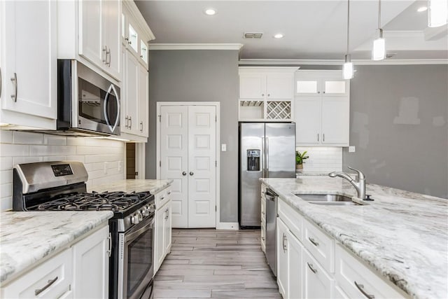 kitchen with visible vents, white cabinets, glass insert cabinets, stainless steel appliances, and a sink