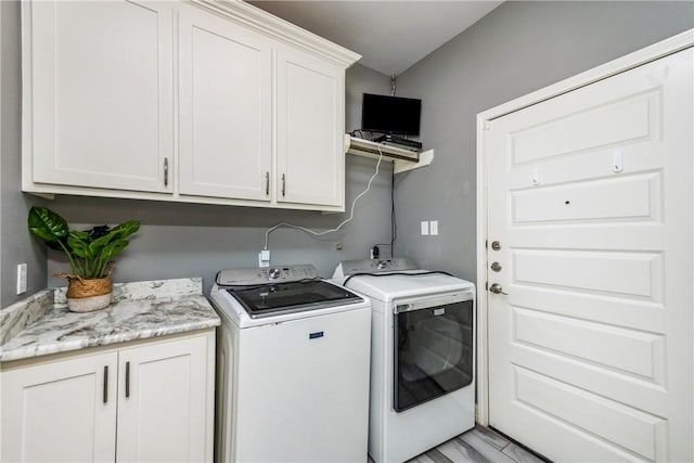 washroom featuring cabinet space and independent washer and dryer