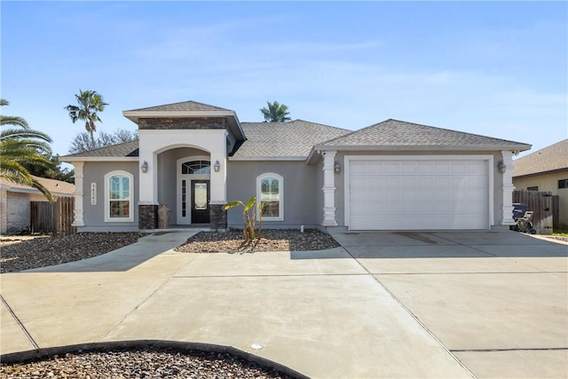 view of front of house featuring driveway, an attached garage, a shingled roof, and stucco siding