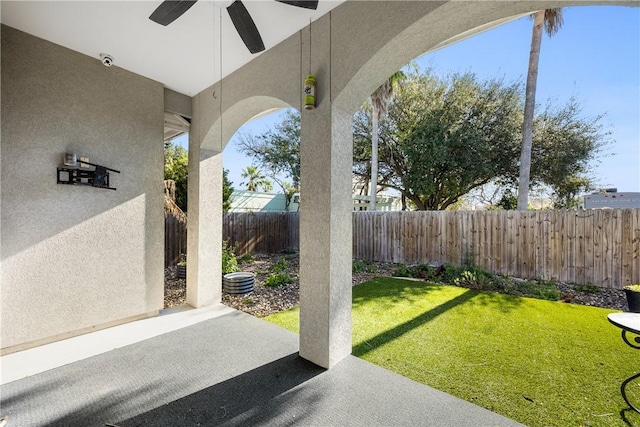 view of yard featuring a fenced backyard, a ceiling fan, and a patio