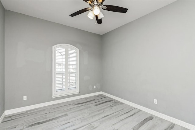 unfurnished room featuring a ceiling fan, light wood-type flooring, and baseboards