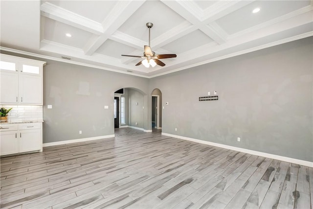 spare room featuring light wood finished floors, ceiling fan, arched walkways, and ornamental molding