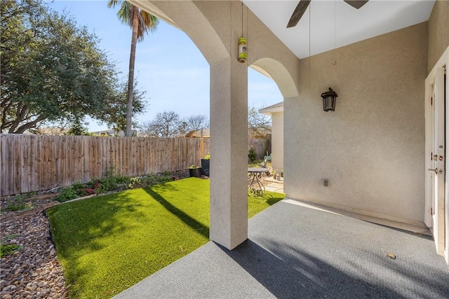 view of yard with a patio area, a fenced backyard, and ceiling fan