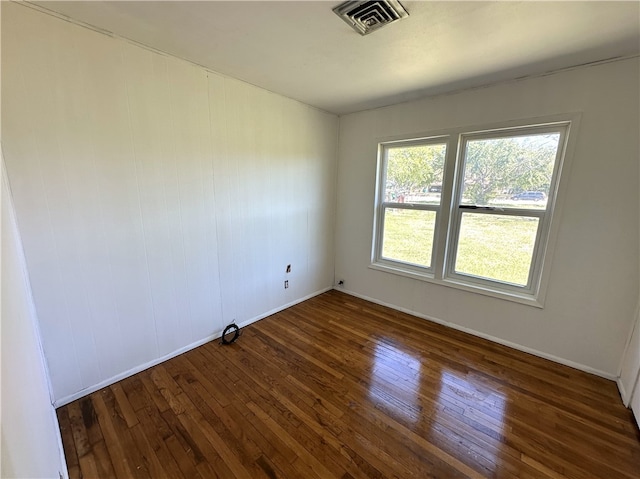 spare room featuring hardwood / wood-style floors, baseboards, and visible vents