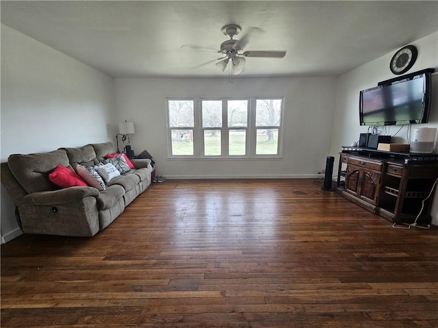 living area with dark wood-type flooring, baseboards, and a ceiling fan