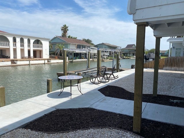 view of dock with a residential view and a water view