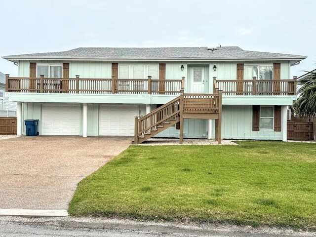 back of house featuring a garage and a lawn