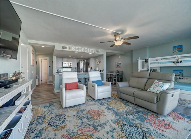 living room with light hardwood / wood-style flooring and ceiling fan