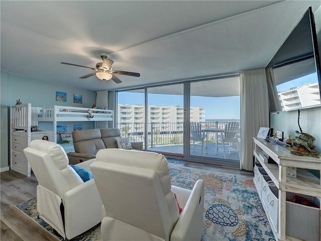 living room with ceiling fan, light hardwood / wood-style floors, and floor to ceiling windows