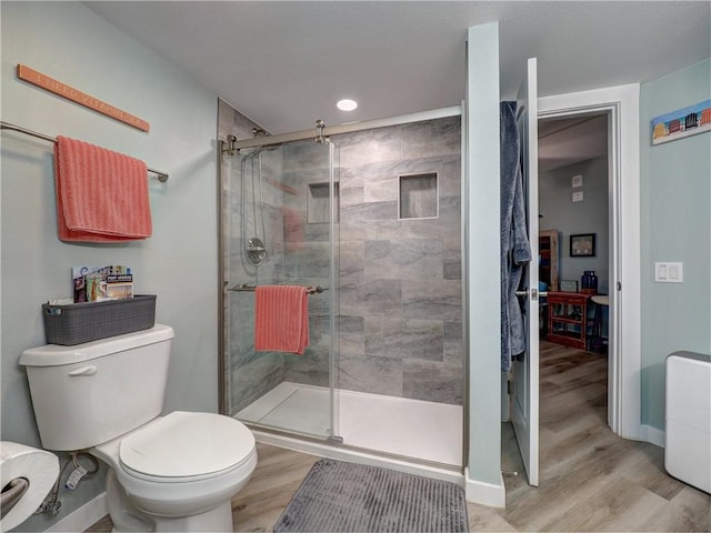 bathroom featuring wood-type flooring, toilet, and walk in shower