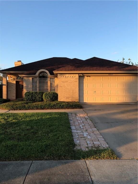 ranch-style house with a garage and a front yard