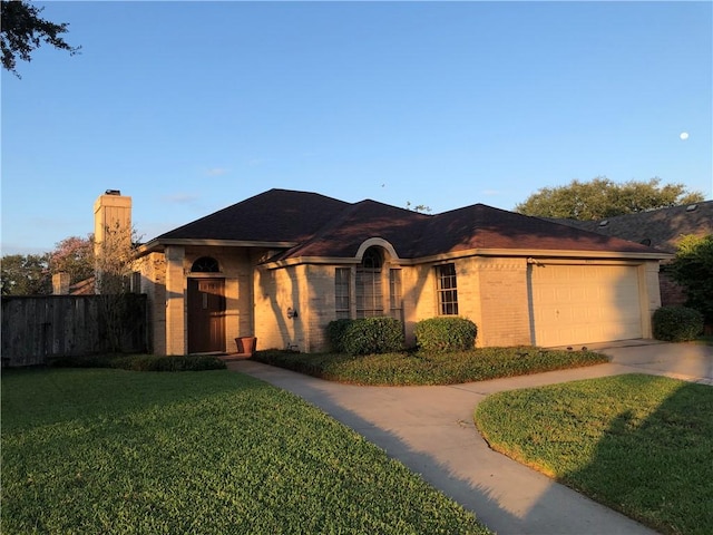 ranch-style house featuring a garage and a front lawn