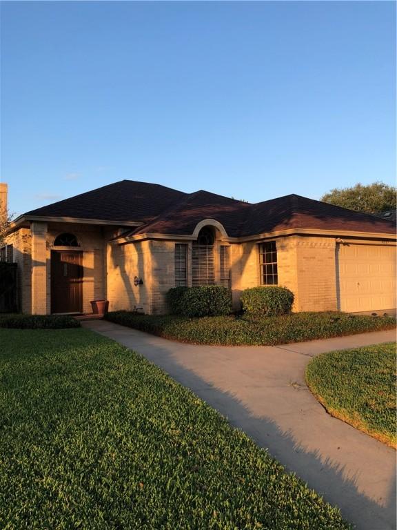 single story home with a garage and a front lawn