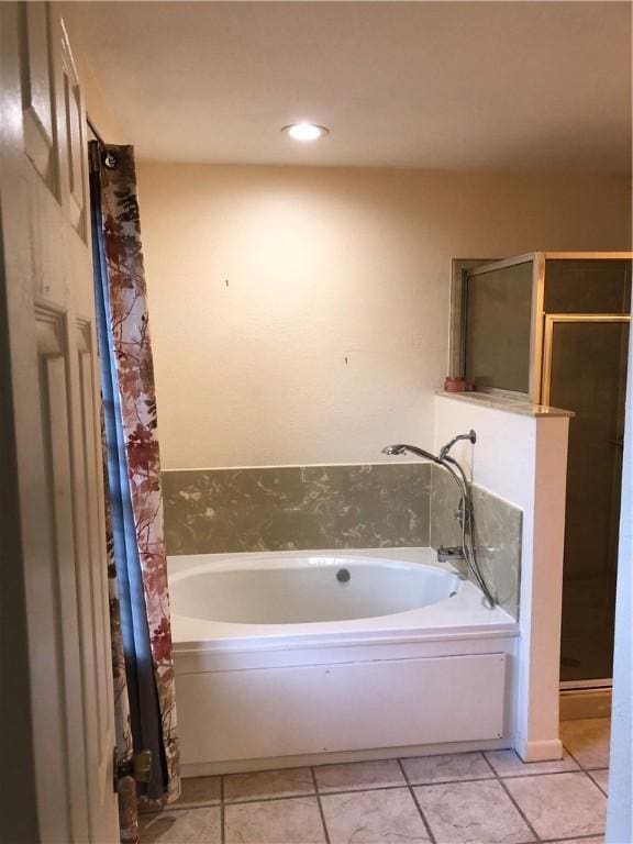 bathroom with a bathing tub and tile patterned flooring