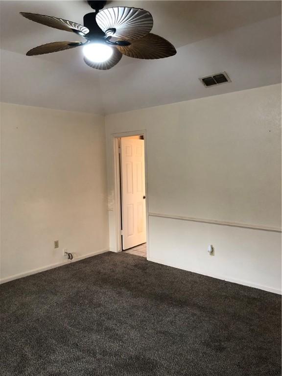 carpeted spare room featuring ceiling fan