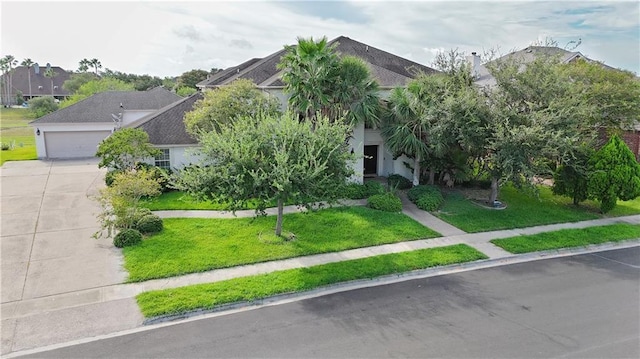 obstructed view of property with a garage and a front lawn