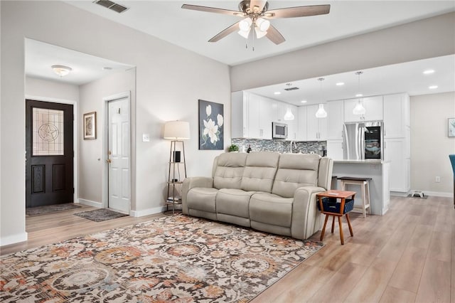 109 Starlight, Ingleside, TX 78362 - living area featuring baseboards, visible vents, light wood-style flooring, and a ceiling fan