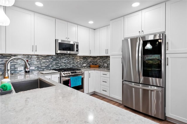 109 Starlight, Ingleside, TX 78362 - kitchen featuring white cabinetry, stainless steel appliances, a sink, and wood finished floors