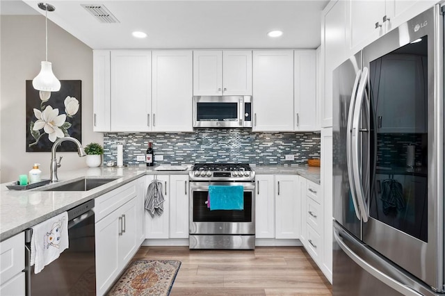 109 Starlight, Ingleside, TX 78362 - kitchen with a sink, stainless steel appliances, white cabinets, visible vents, and tasteful backsplash