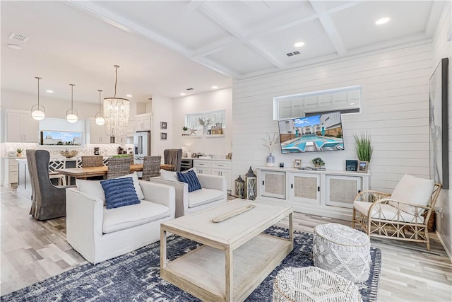 living room featuring light hardwood / wood-style floors, beam ceiling, wooden walls, and coffered ceiling