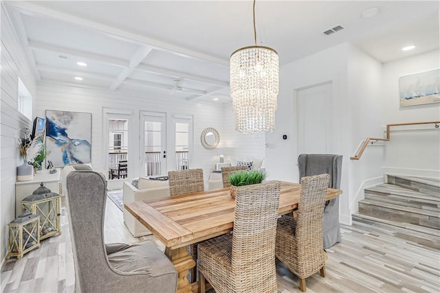 dining area with a chandelier, beam ceiling, light wood-type flooring, and coffered ceiling