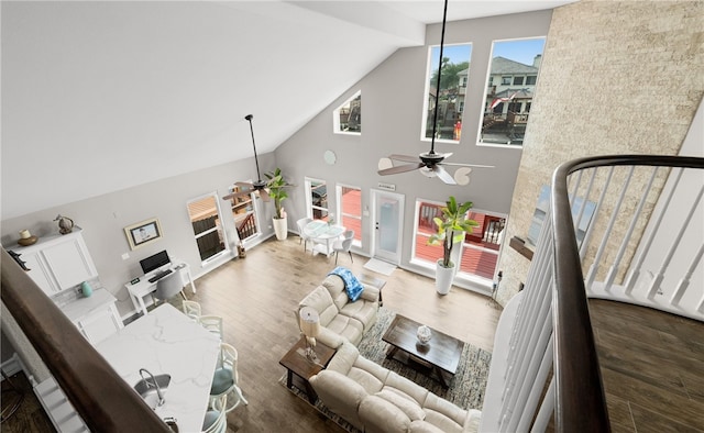 living room with dark hardwood / wood-style floors, ceiling fan, and high vaulted ceiling