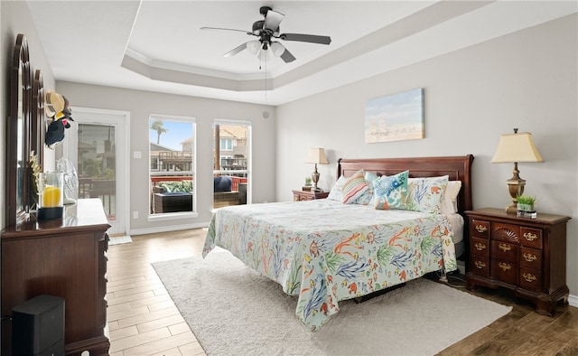 bedroom with wood-type flooring, a raised ceiling, and ceiling fan