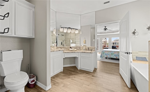 bathroom featuring vanity, ceiling fan, wood-type flooring, toilet, and a bathing tub