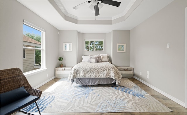 bedroom featuring hardwood / wood-style flooring, multiple windows, ornamental molding, and ceiling fan