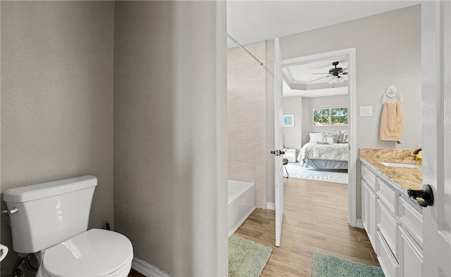 full bathroom featuring shower / bathtub combination, vanity, ceiling fan, hardwood / wood-style flooring, and toilet