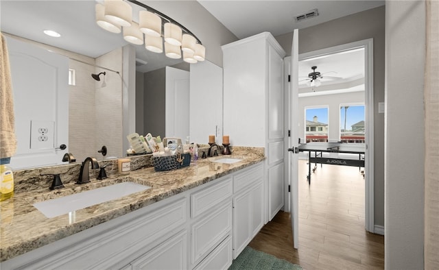 bathroom with hardwood / wood-style floors, ceiling fan, and vanity