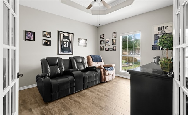 cinema with ceiling fan, a healthy amount of sunlight, wood-type flooring, and french doors