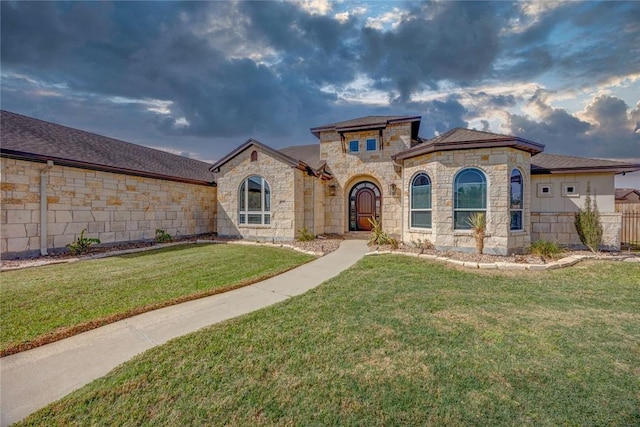 view of front of property featuring a front lawn, fence, and stone siding