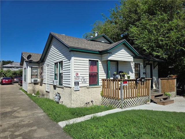 bungalow-style house with a shingled roof, crawl space, a deck, cooling unit, and brick siding