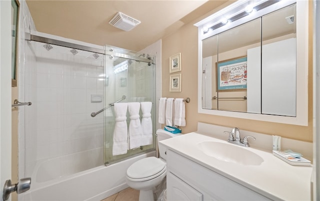 full bathroom with bath / shower combo with glass door, vanity, toilet, and tile patterned flooring