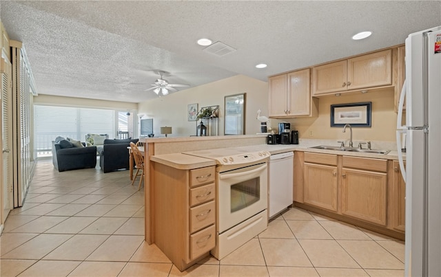 kitchen with kitchen peninsula, sink, white appliances, and a textured ceiling