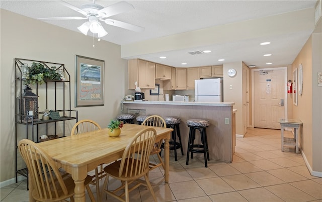 dining space featuring light tile patterned flooring, ceiling fan, and a textured ceiling