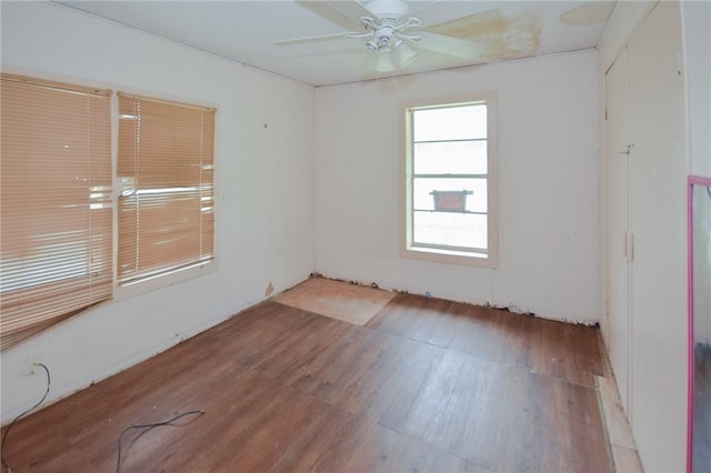 empty room featuring ceiling fan, a healthy amount of sunlight, and wood finished floors