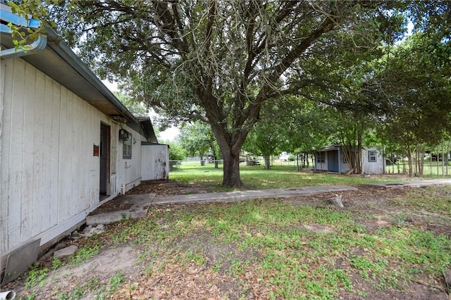 view of yard with fence, a storage shed, and an outdoor structure