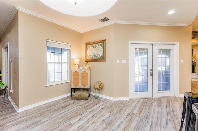 entrance foyer featuring visible vents, wood finished floors, crown molding, and french doors