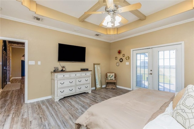 bedroom with wood finished floors, visible vents, baseboards, access to outside, and a tray ceiling