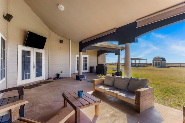 view of patio featuring french doors, fence, a storage unit, an outdoor structure, and an outdoor living space