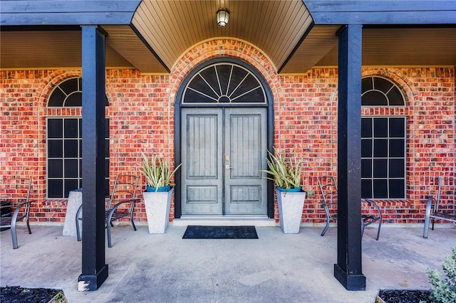 entrance to property featuring brick siding