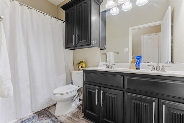 full bath featuring double vanity, toilet, wood finished floors, curtained shower, and a sink