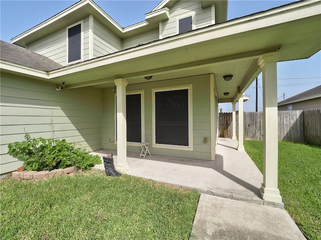 entrance to property featuring a patio area and a yard