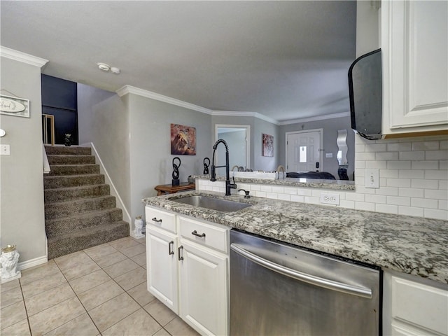 kitchen featuring white cabinets, sink, light tile patterned floors, stainless steel dishwasher, and backsplash