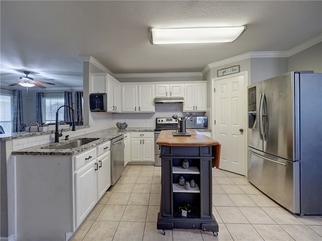 kitchen featuring sink, kitchen peninsula, appliances with stainless steel finishes, backsplash, and white cabinets