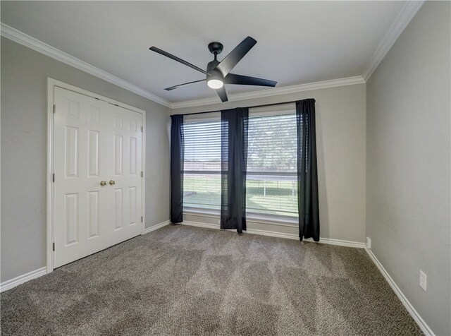 carpeted empty room with ceiling fan and ornamental molding